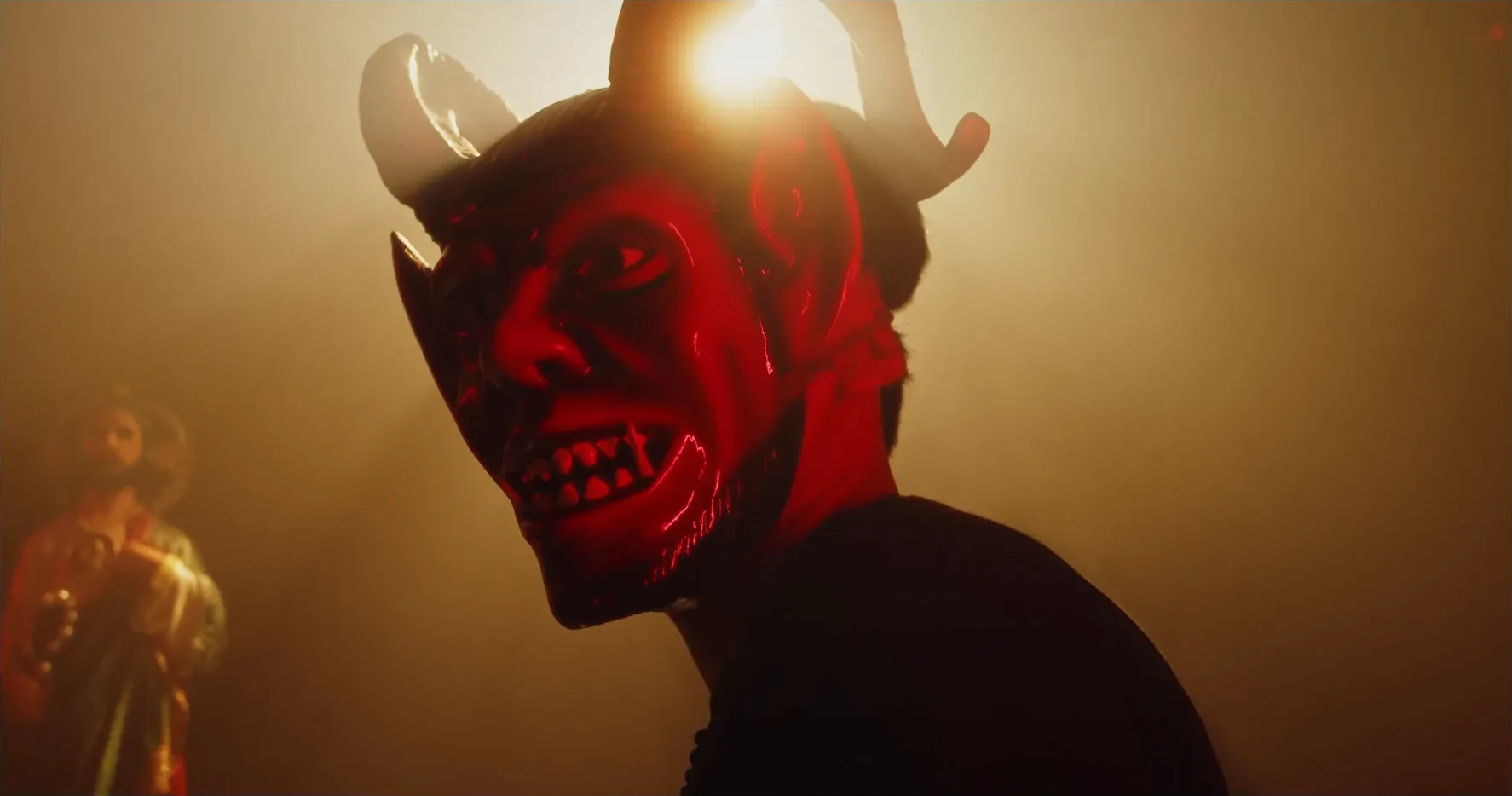 Fotograma: personaje enmascarado bajo luz roja
