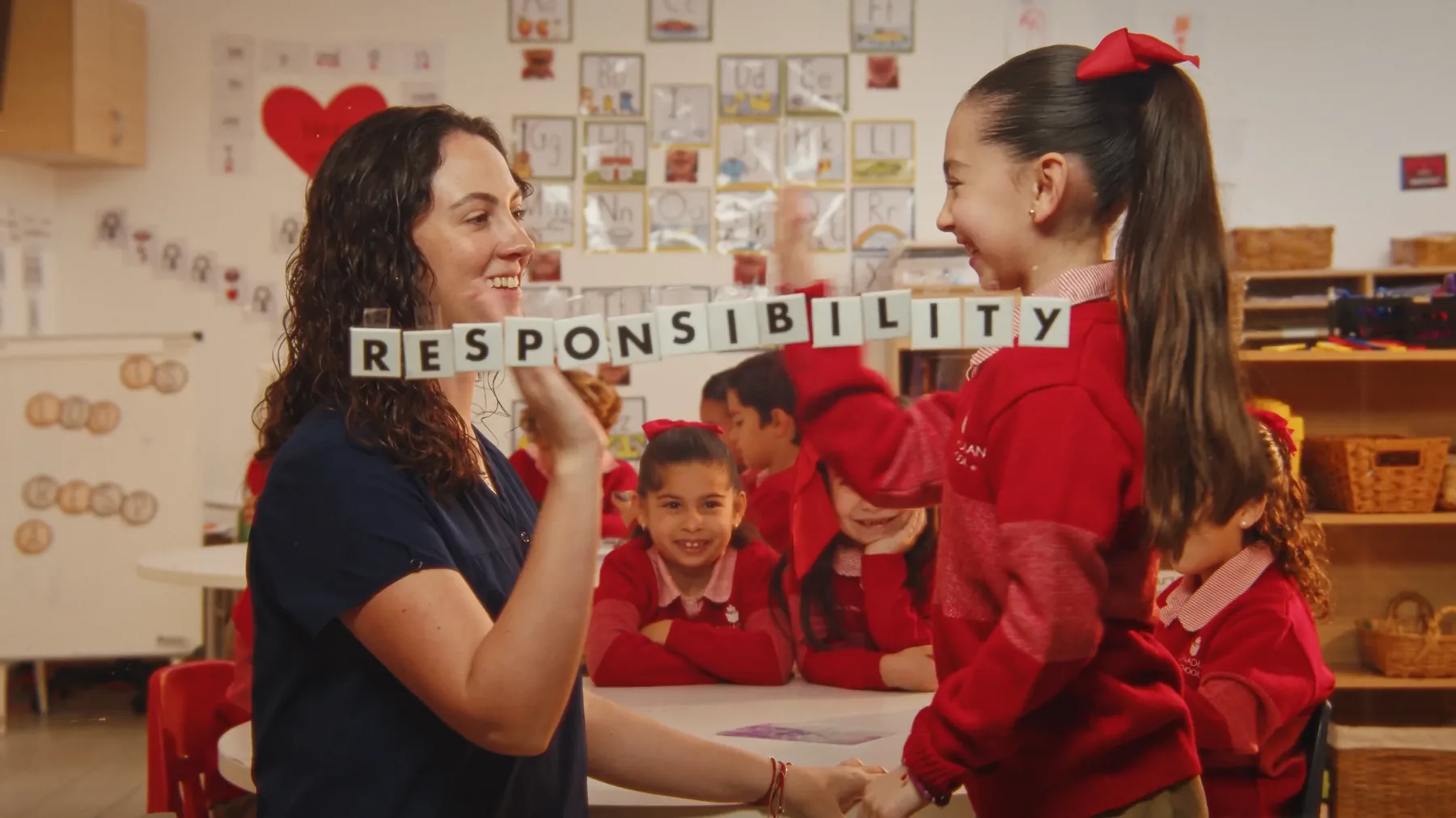 Maestra y alumnas con letras que forman RESPONSIBILITY
